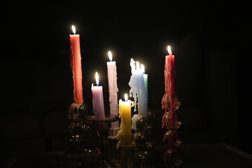 Candle flames in darkness reflecting occult energy, sacred rituals, mystic traditions, hidden...