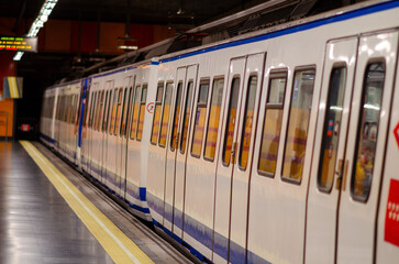 A modern metro train stands at an empty underground platform, ready for passengers. Urban transportation, public transit and city infrastructure concept.