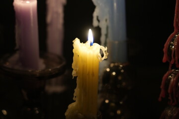 Candle flames in darkness reflecting occult energy, sacred rituals, mystic traditions, hidden...