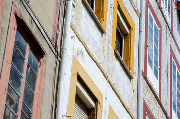 Historic European architecture featuring aged walls and vibrant window frames; urban atmosphere with weathered textures and authentic details for design projects.