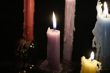 Candle flames in darkness reflecting occult energy, sacred rituals, mystic traditions, hidden...
