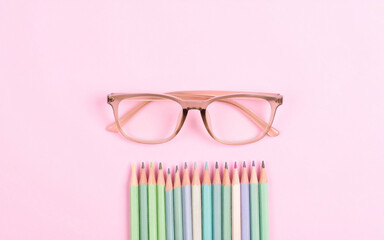 Pastel Glasses and Colored Pencils on Pink Background – Minimal Flat Lay for Creative Aesthetic