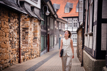 Woman Walking Down Narrow Historic Street with Laptop Sleeve