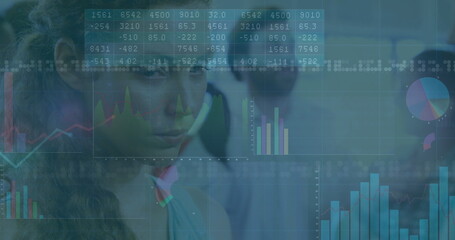 Analyzing Asian woman reviewing tables and charts on digital displays in office analytics