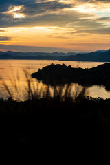 Golden sunset over Labuan Bajo Island with sea reflections and silhouetted hills in peaceful scenery