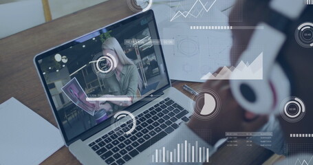 Displaying laptop showing presenter in blazer, printed materials at desk, notebook pen headphones