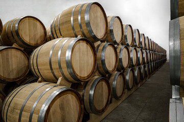 Mass producing wine. Stacked barrels of wine at wine distillery.  cellar. whiskey barrels. wooden...