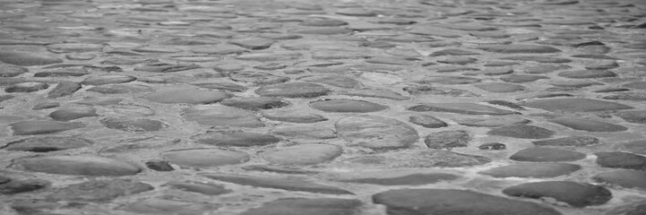 Old cobblestone sidewalk, pavement as backdrop, perspective view. Skadarska street, Belgrade, Serbia. Granite cobblestone pavement background. Perspective view
