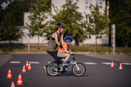 Child Practicing Bike Riding with Adult Guidance Outdoors