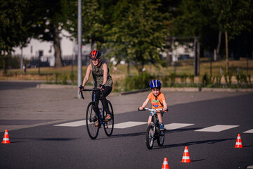 Child and Adult Biking Through Cones During Outdoor Practice