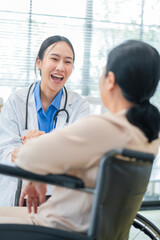 Smiling doctor provides compassion care for mature female patient in wheelchair during hospital...