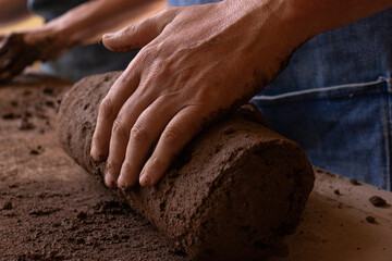 Close up hand of a man’s hand kneading clay to make a ceramic piece in his workshop, demonstrating a handcraft process, calm, focus and peaceful. 