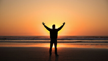 Fototapeta premium Golden sunset silhouette of a woman embracing freedom with yoga on the beach