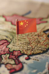 Chinese flag pinned to a vintage map, symbolizing China's location and global presence. Travel and political concept.