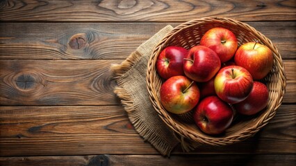 A rustic wicker basket brimming with a harvest of vibrant red apples rests on a weathered wooden surface, adorned with a burlap placemat.