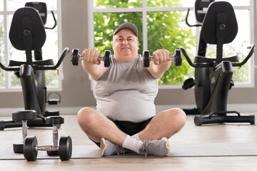 Man exercising in gym, lifting weight, lifting dumbbell equipment. Mature male workout dumbbell in gym. Fitness, gym and exercising