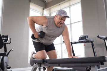Man exercising in gym, lifting weight, lifting dumbbell equipment. Mature male workout dumbbell in gym. Fitness, gym and exercising