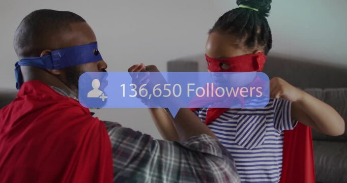 Father and daughter in masks and capes locking hands, arm wrestling updating digital follower count