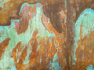 Rusty metal texture with orange, green, and blue colors.

