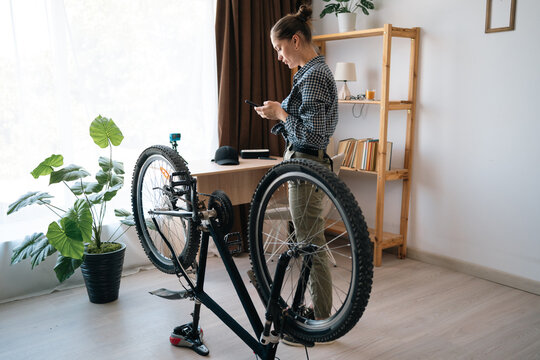 Woman repairing bicycle using online assistant repairing bicycles at home