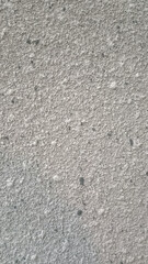 Coarse-grained texture resembling concrete or stone, with light gray color and small specks.


