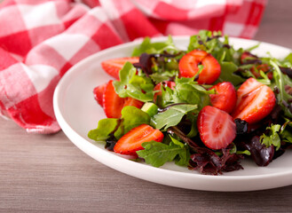 Green salad with strawberry and balsamic on plate
