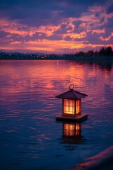 Glowing lantern floating on a calm body of water at dusk