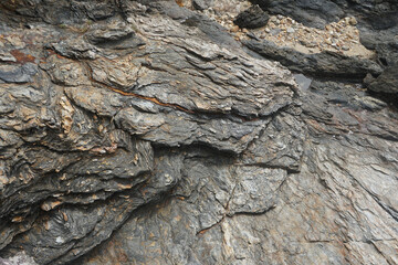 Schist forms from the transformation of other rocks under high pressure and temperature during metamorphism. Schist rocks eroded by wind and sea waves.     