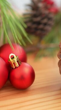 Vertical A splendidly adorned Christmas ball on rustic wooden table, lending its decorative brilliance to the holiday background. Scene of merriment for a joyous Christmas celebration. 