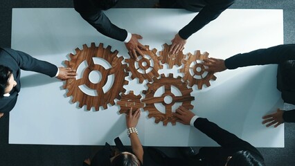 Top view of business people gather wooden cog together at meeting. Group of project manager helping...