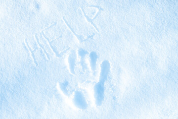 A hand print in the snow with the word HELP written in the snow