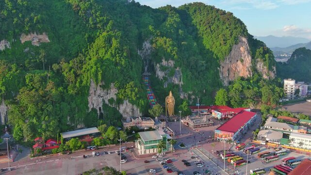 Kuala Lumpur, Malaysia: Aerial drone view of capital city of Malaysia, famous Batu Caves at sunset - landscape panorama of Southeast Asia from above

