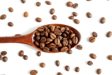 On a white background lies a wooden spoon with coffee beans.	