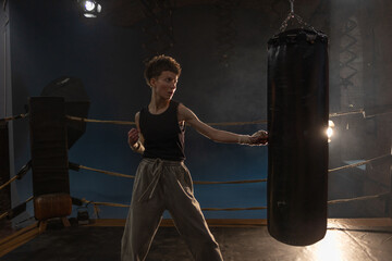 Boxing with a punching bag, sports achievements concept, female wrestler in a boxing ring,...