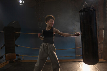 Female boxer training in cinematic gym lighting, powerful punch on bag with colorful dynamic lights
