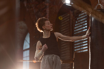 Woman boxer in ring with cinematic lighting, throwing powerful punch during intense training