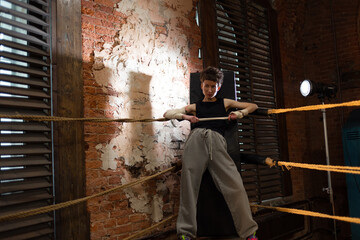 pause between workouts in the corner of the ring. A woman is leaning on a corner stand, a boxing...