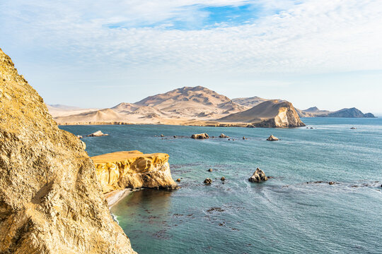 Coastal cliffs and the desert dunes in Paracas National Reserve, Peru. Dramatic landscape with El Playon beach in the distance.