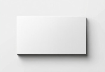Fototapeta premium A blank white rectangular card is displayed on a clean white surface with a subtle