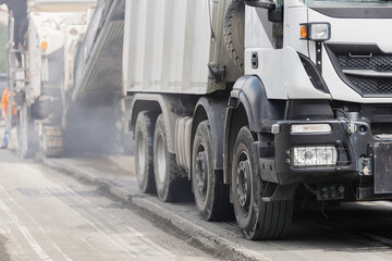 Asphalt Milling Machine Loading Debris into Dump Truck During Road Reconstruction