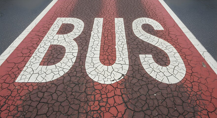 Bus lane marking with cracked red paint on an asphalt road surface illustrating urban transport infrastructure