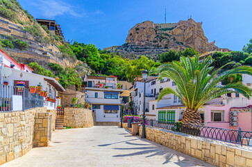 Alicante old town Santa Cruz neighborhood narrow street, typical white houses and Mount Benacantil rock, Casco Antiguo Santa Cruz quarter in Alicante city historic centre, Valencian Community, Spain