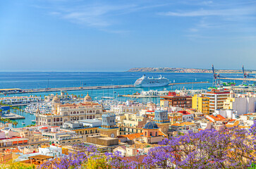 Aerial panoramic view of old town Alicante, panorama of Alicante city historic centre, centro Alacant, Port of Alicante with cruise ship in Bahia de Alicante bay of Mediterranean Sea horizon, Spain