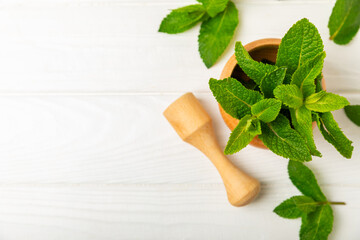Fresh mint with mortar and pestle on wooden background. Melissa leaves. Healing herbs green mint...