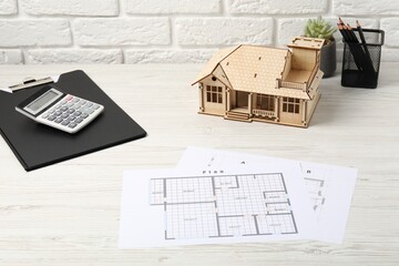 Real estate. House model, floor plan and calculator on white wooden table