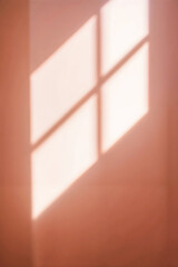 La lumière qui perce au travers d'une fenêtre et se reflète sur un mur couleur rose orangée, ombre de la fenêtre projetée sur le mur