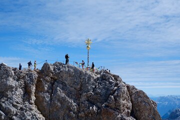 Gipfelkreuz der Zugspitze mit Wanderern im Sommer
