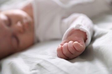 Cute newborn baby sleeping on bed, selective focus