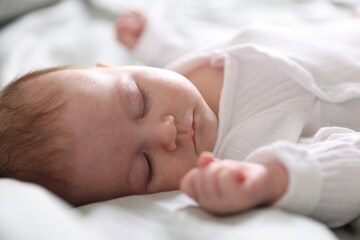 Cute newborn baby sleeping on bed, closeup