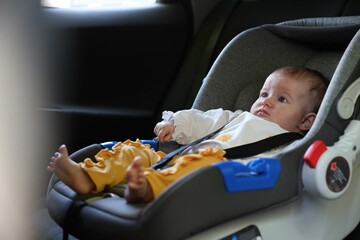 Cute little baby fastened in car seat